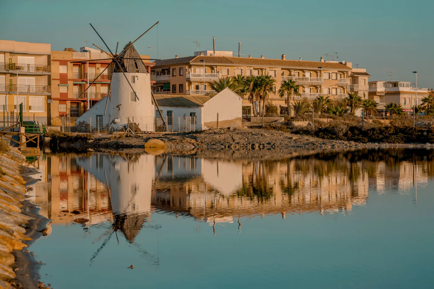 El molino blanco de San Pedro del Pinatar reflejado en el agua quieta de las salinas
